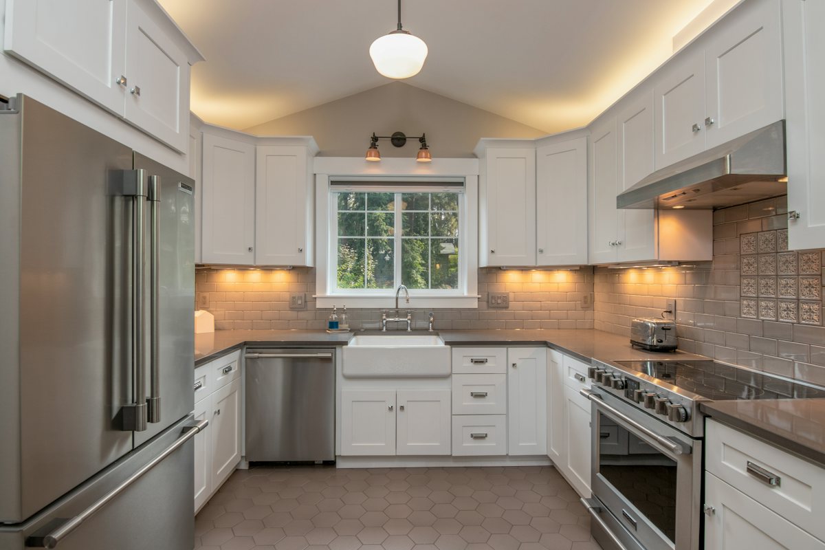 Kitchen with white cabinets and a pendant light over the counter